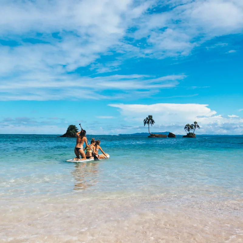 Shallow turquoise water off a white sand beach
